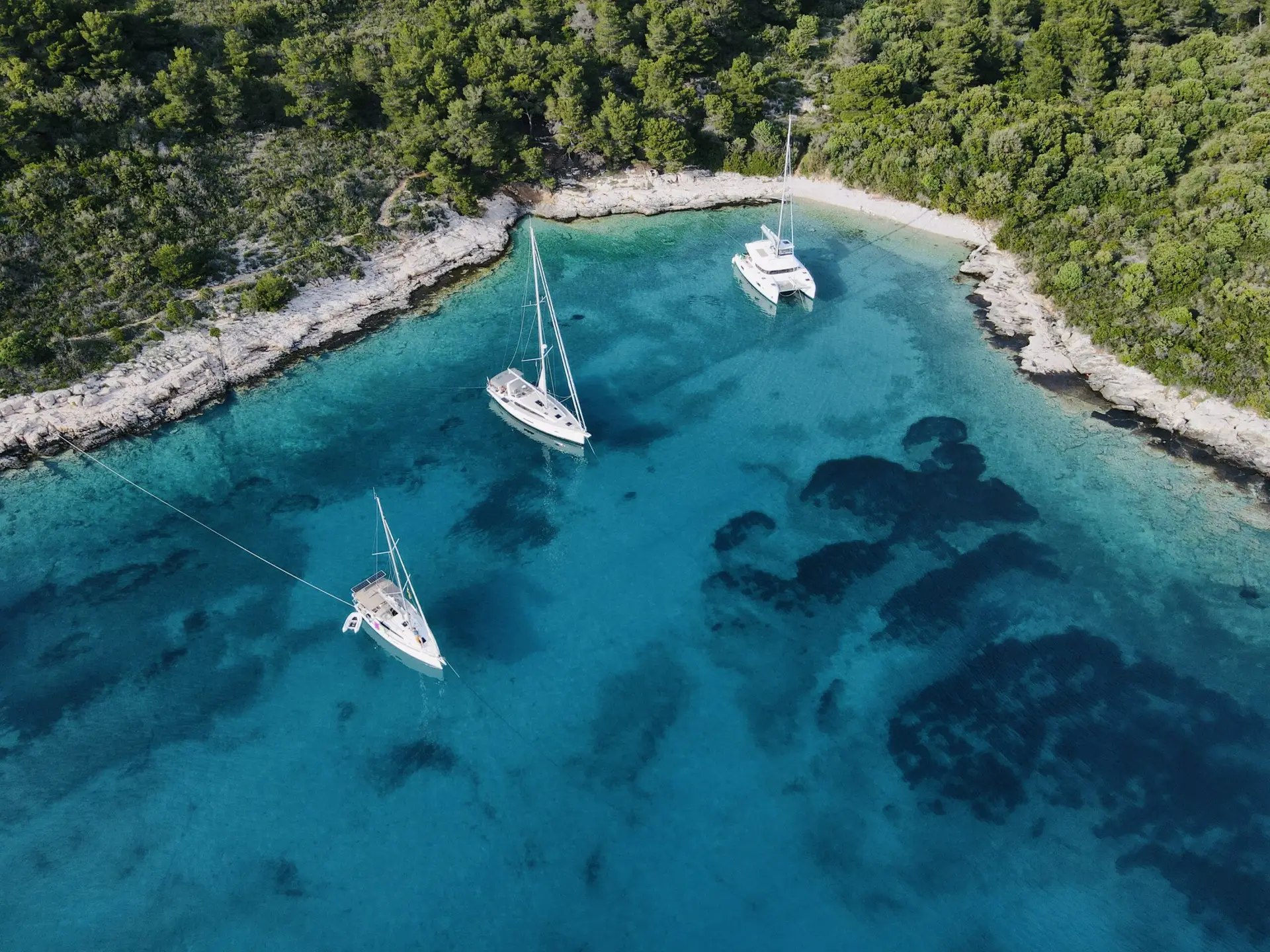 Catamaran and monohull sailing yachts anchored in the bay along the Croatian coast
